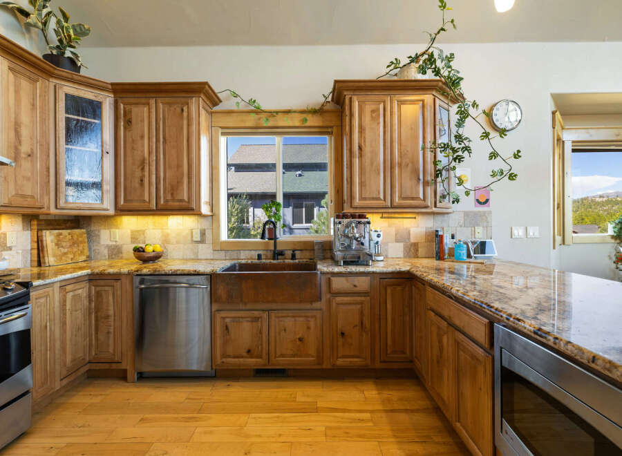 Step into culinary bliss with this stunning kitchen! Featuring custom wooden cabinetry, a stainless steel dishwasher, and a beautiful copper sink, this space is designed for both style and functionality.