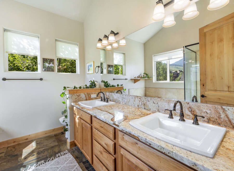 Step into luxury with this stunning bathroom featuring a double vanity with a beautiful granite countertop.