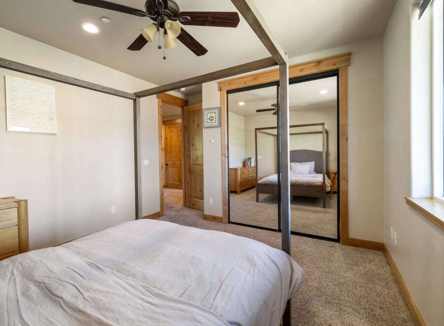 Step into this inviting bedroom, featuring a stylish canopy bed and ample natural light.