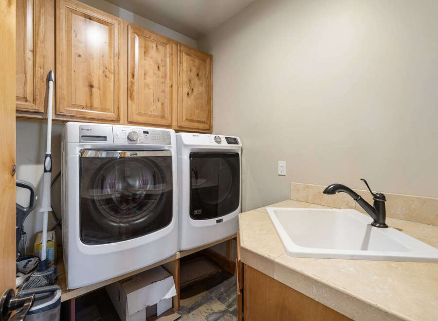 This laundry room features a modern design with a Maytag washer and dryer set.