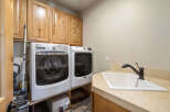 This laundry room features a modern design with a Maytag washer and dryer set.