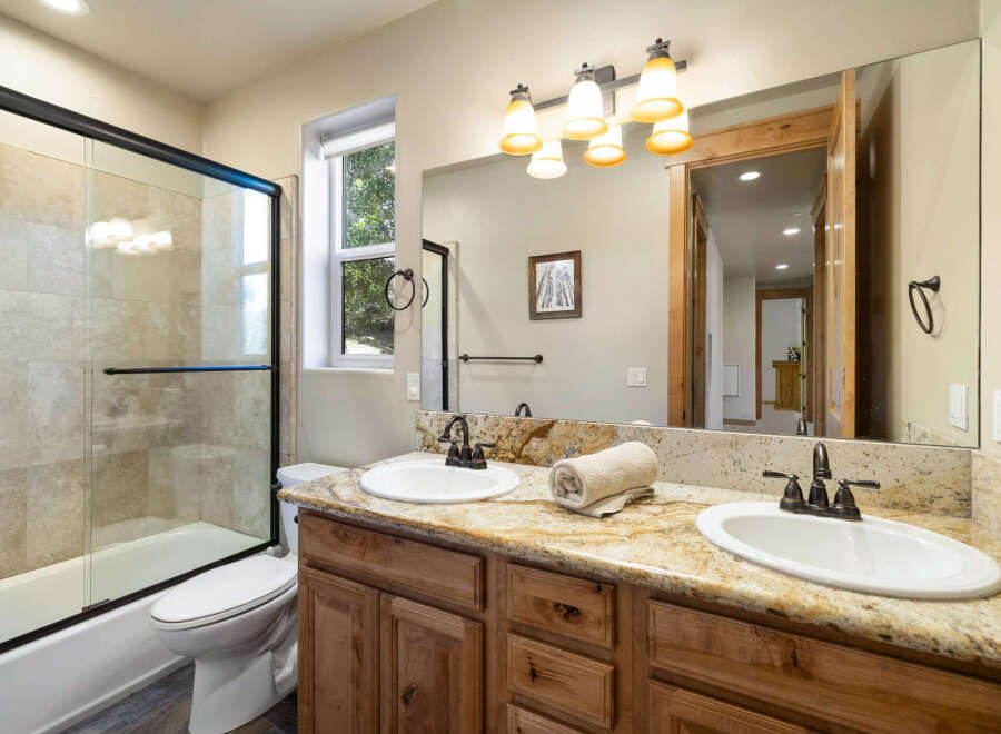 This stunning bathroom features a luxurious granite countertop with dual sinks, perfect for a shared space.