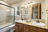 This stunning bathroom features a luxurious granite countertop with dual sinks, perfect for a shared space.