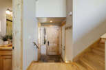 Step into this inviting entryway, showcasing a beautiful wooden door and a welcoming staircase.