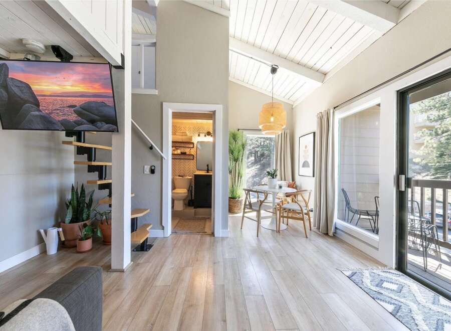 Discover this stunning property featuring a modern interior with a spiral staircase and a sleek, wall-mounted TV.