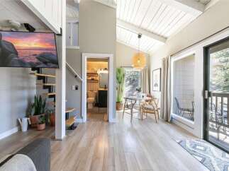 Discover this stunning property featuring a modern interior with a spiral staircase and a sleek, wall-mounted TV.