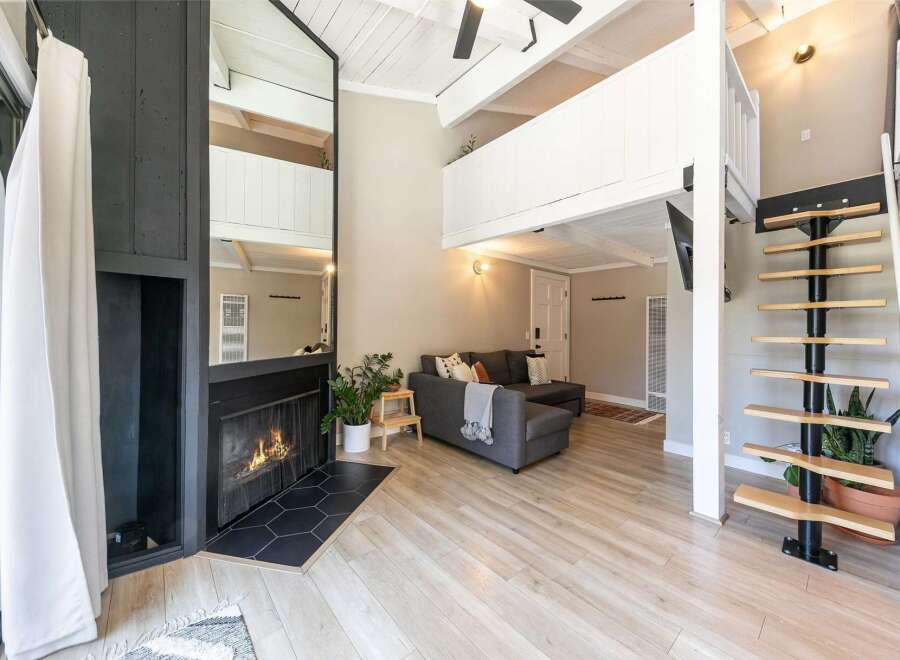 This stunning property boasts a modern living space with a cozy fireplace and a stylish staircase.