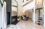 This stunning property boasts a modern living space with a cozy fireplace and a stylish staircase.