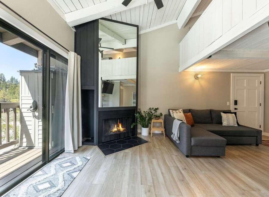 Experience cozy living in this stunning property featuring a fireplace and a comfortable sectional sofa.