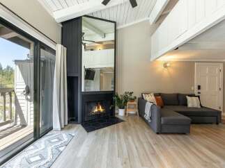 Experience cozy living in this stunning property featuring a fireplace and a comfortable sectional sofa.