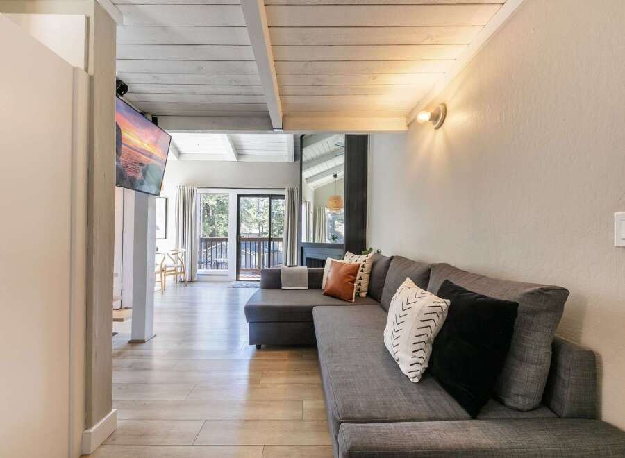 This stunning property boasts a modern living space with a comfortable sectional sofa and stylish accent pillows.