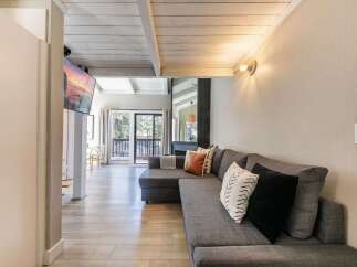 This stunning property boasts a modern living space with a comfortable sectional sofa and stylish accent pillows.