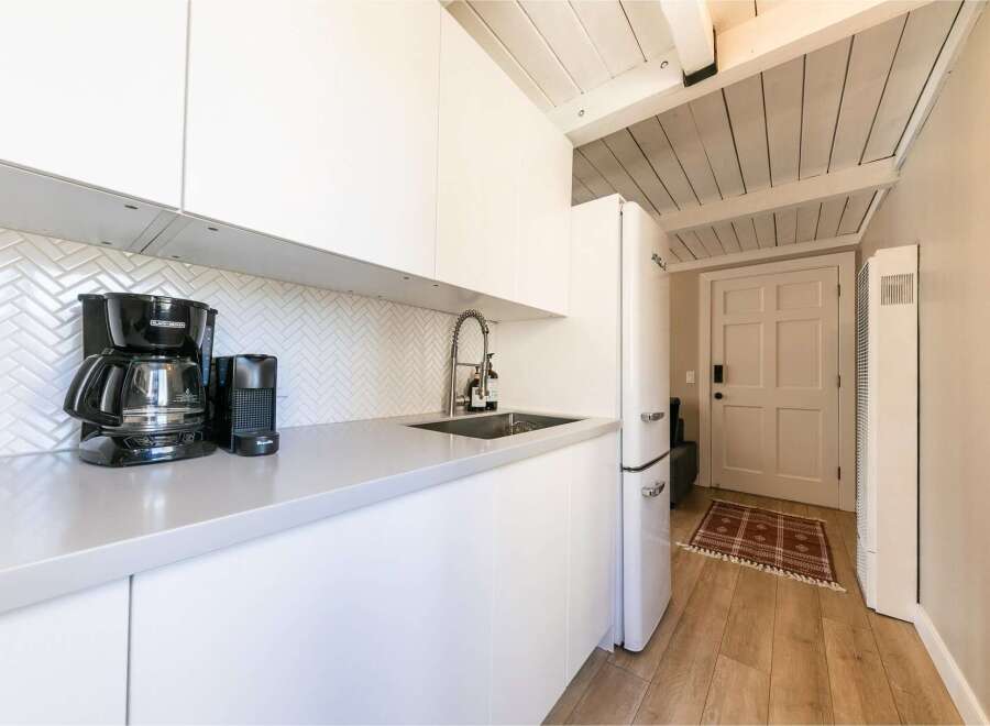 This modern kitchen features sleek white cabinetry and a minimalist design, perfect for a contemporary lifestyle.