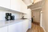 This modern kitchen features sleek white cabinetry and a minimalist design, perfect for a contemporary lifestyle.