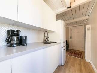 This modern kitchen features sleek white cabinetry and a minimalist design, perfect for a contemporary lifestyle.