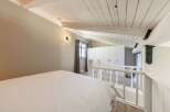 Discover the charm of this unique loft bedroom, featuring a cozy bed and a stylish white railing.