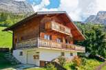 Discover a stunning wooden chalet nestled in a picturesque mountain setting.