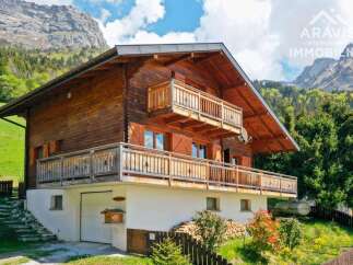 Discover a stunning wooden chalet nestled in a picturesque mountain setting.