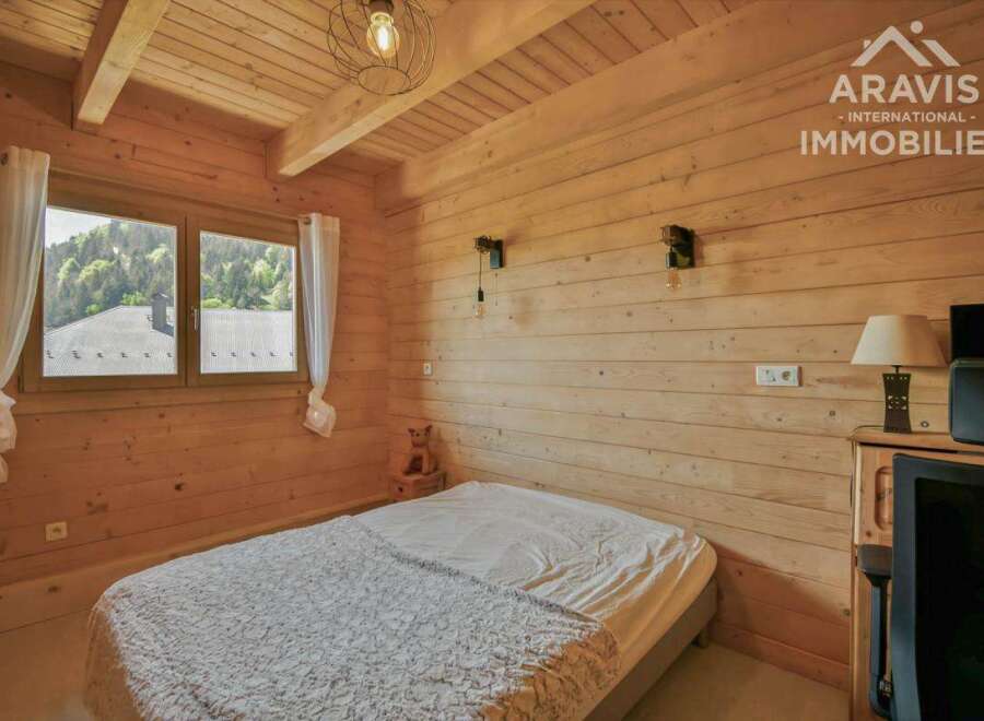 Discover the charm of this cozy bedroom featuring natural wood paneling and a serene ambiance.
