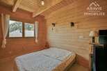 Discover the charm of this cozy bedroom featuring natural wood paneling and a serene ambiance.