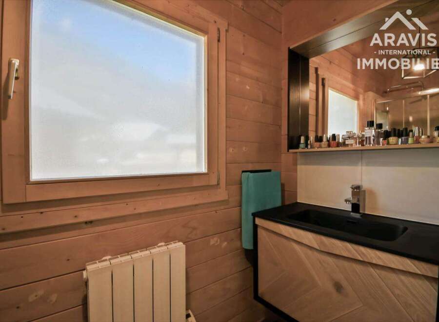 Discover this charming bathroom featuring a stylish black sink and a beautifully designed wooden vanity.