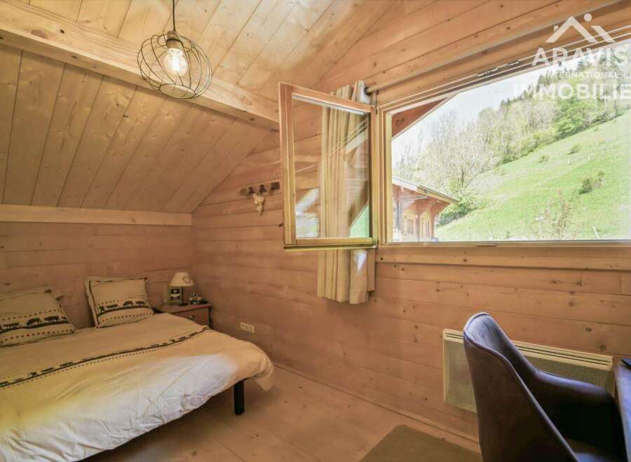 Discover the charm of this cozy bedroom, featuring warm wooden paneling and a bright, airy feel.