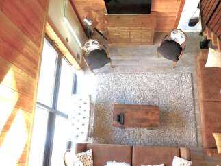 Step into luxury with this stunning property, featuring a cozy living room with a plush rug and comfortable seating.