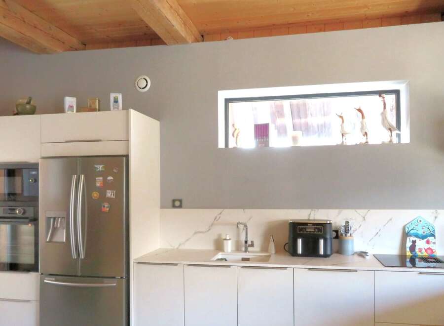 This modern kitchen boasts sleek white cabinetry, stainless steel appliances, and a stunning marble countertop.