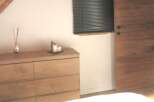 This charming bedroom features a beautiful wooden dresser, perfect for storage and adding a touch of rustic elegance.