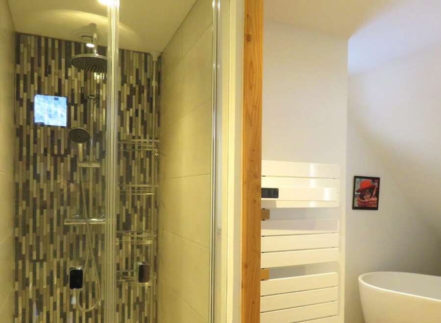 Step into luxury with this stunning bathroom featuring a modern shower with a unique mosaic tile design.