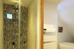 Step into luxury with this stunning bathroom featuring a modern shower with a unique mosaic tile design.