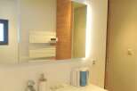 Step into this modern bathroom, featuring a sleek, illuminated mirror that enhances the space.