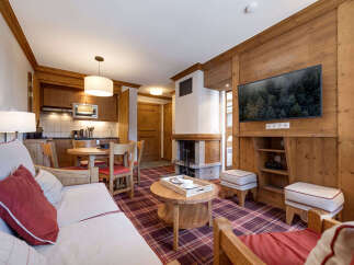 Experience the warmth of this charming apartment, featuring a cozy living area with a fireplace and a modern kitchen.