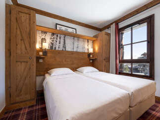 Experience the charm of this cozy bedroom featuring two comfortable beds, perfect for a relaxing stay.