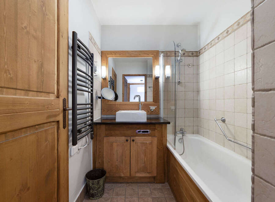 This charming bathroom features a warm, inviting design with natural wood accents.