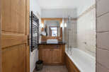 This charming bathroom features a warm, inviting design with natural wood accents.
