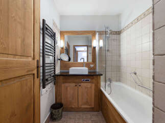 This charming bathroom features a warm, inviting design with natural wood accents.