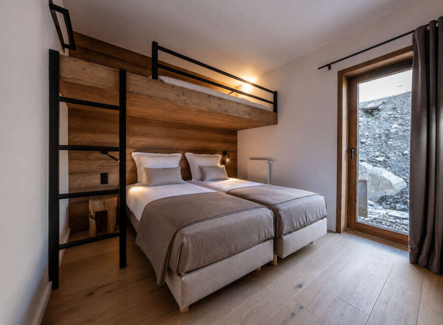 Discover the charm of this cozy bedroom featuring a unique bunk bed design, perfect for families or groups.