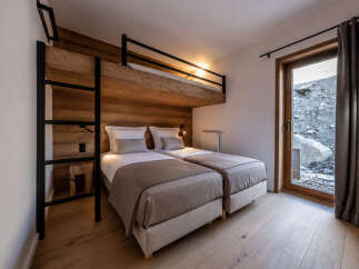 Discover the charm of this cozy bedroom featuring a unique bunk bed design, perfect for families or groups.