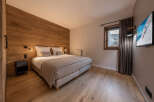 Experience luxury in this stunning bedroom featuring a warm wooden accent wall and elegant design.