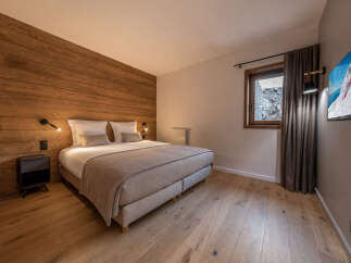 Experience luxury in this stunning bedroom featuring a warm wooden accent wall and elegant design.