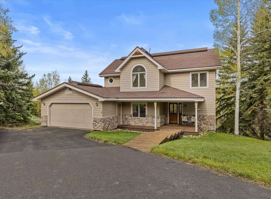 This stunning property boasts a beautiful exterior with a combination of stone and siding, creating a warm and inviting curb appeal.