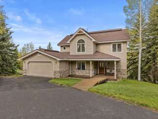 This stunning property boasts a beautiful exterior with a combination of stone and siding, creating a warm and inviting curb appeal.