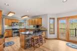 This stunning kitchen boasts a beautiful stone island with a sleek black countertop, perfect for entertaining.