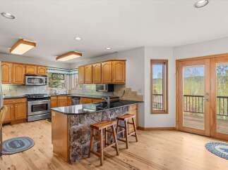 This stunning kitchen boasts a beautiful stone island with a sleek black countertop, perfect for entertaining.
