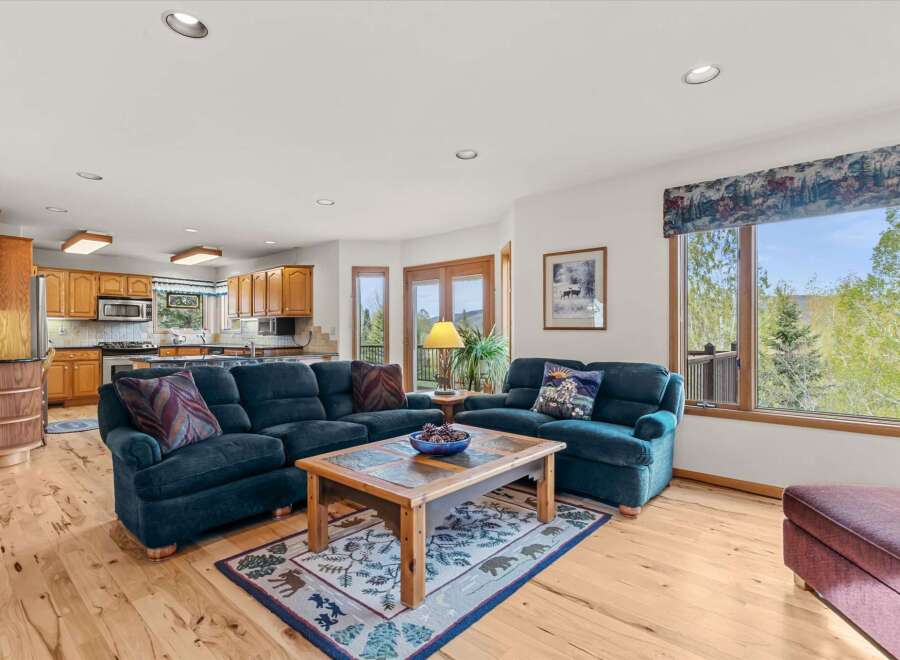 This stunning living space features a cozy seating area with a plush, navy blue sectional and armchair, perfect for relaxing.