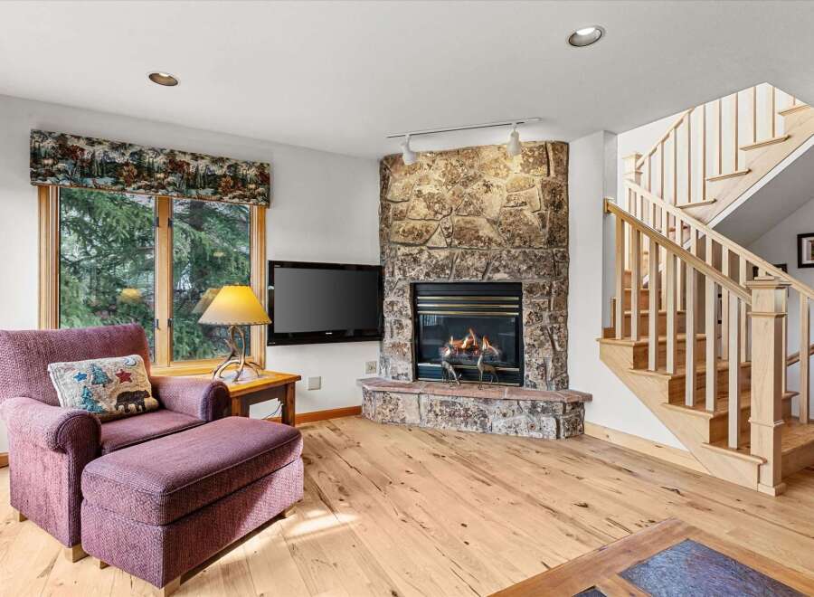 This cozy living room features a stunning stone fireplace, perfect for those chilly evenings.