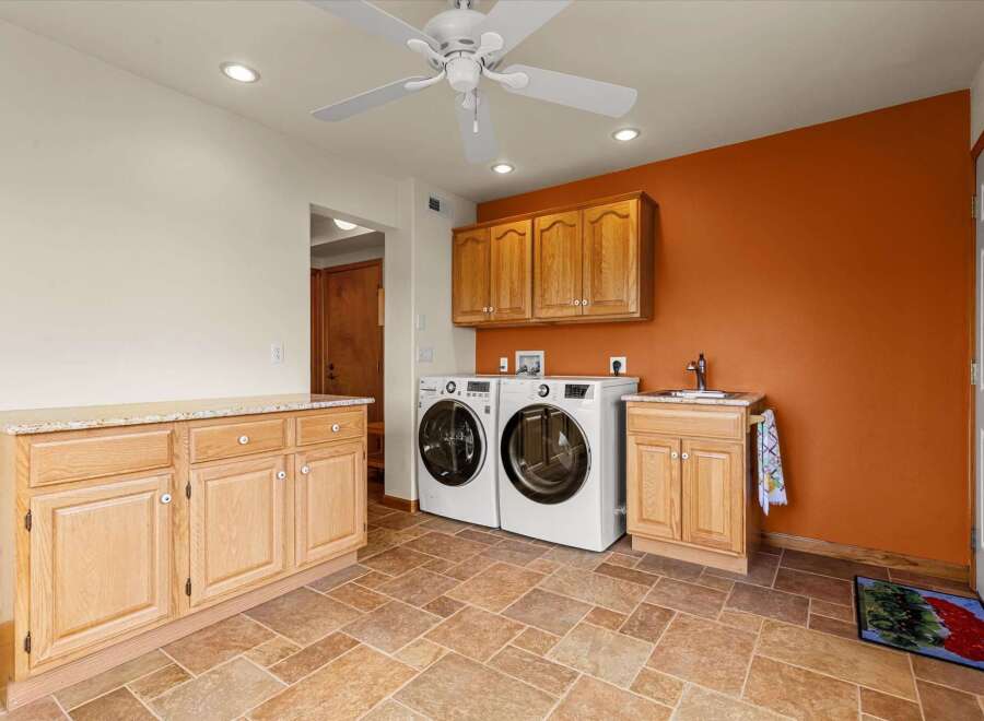 This laundry room boasts a functional design with ample storage and modern appliances.