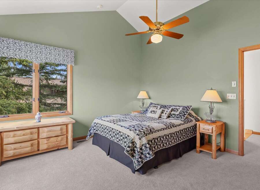 This cozy bedroom features a rustic wooden dresser and nightstands, adding warmth and character to the space.