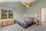 This cozy bedroom features a rustic wooden dresser and nightstands, adding warmth and character to the space.
